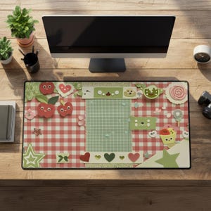May include: A rectangular desk mat featuring a red and white gingham pattern background with a central light green grid panel. The design includes various decorative elements like cartoon apples, hearts, stars, and small smiling faces.