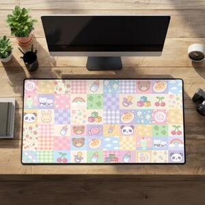 May include: A rectangular desk mat featuring a grid pattern of pastel-colored squares. Each square displays various illustrations including teddy bear faces, baby bottles, pacifiers, cherries, rainbows, pandas, building blocks, and strawberries.