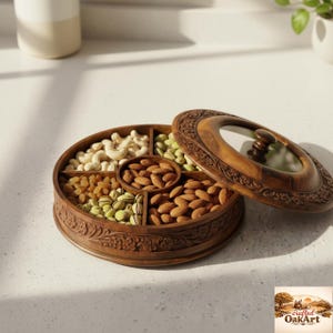 Puede incluir: Una bandeja redonda de madera con tapa de cristal, llena de frutos secos variados. La bandeja está dividida en secciones que contienen anacardos, almendras, pistachos y pasas. La tapa está parcialmente abierta.
