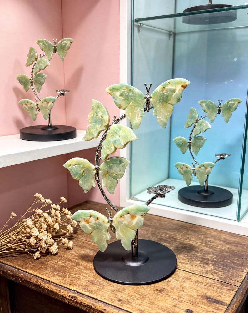 a decorative butterfly sculpture on a wooden table, with a glass display case in the background.