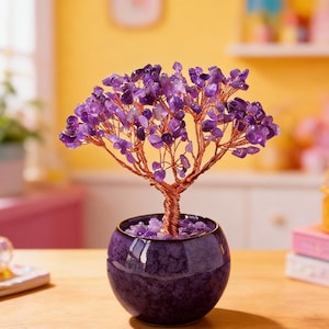 May include: A decorative amethyst tree sculpture. The tree features a copper wire trunk and branches, adorned with purple amethyst stones. It is potted in a round, dark purple ceramic pot. The tree is displayed on a wooden surface.