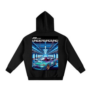 May include: Black hoodie with a graphic on the back depicting a teal and purple car with gold rims. The graphic reads "JDM Car Meet Underground" in white text, set against a blue and grey background.