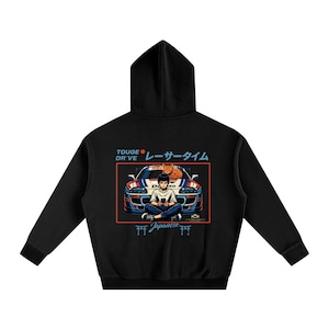 May include: Black hooded sweatshirt with a graphic featuring a car, a person, and a cat. The design includes Japanese text and a red rectangular border. The car is blue, white, and red.