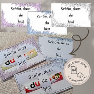 May include: A collection of rectangular paper cards featuring the German text "Schön, dass da bist" and floral border illustrations. Some cards are displayed with chocolate bars attached, while a circular badge indicates a PDF digital download.