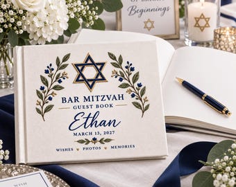 Könnte beinhalten: Ein rechteckiges Gästebuch mit cremefarbenem Stoffeinband, verziert mit einem blauen Davidstern, floralen Zweigen und dem Text Bar Mitzvah, Ethan, March 13, 2027, sowie Wishes, Photos, Memories. Ein dunkelblauer und goldener Stift liegt auf den Seiten.