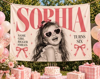 Könnte beinhalten: Ein großes rechteckiges Stoffbanner mit dem Namen SOPHIA in fetten rosa Buchstaben, einem Schwarz-Weiß-Foto eines Kindes mit herzförmiger Sonnenbrille, dem Text SAME GIRL BIGGER SMILES und TURNS SIX sowie rosa Schleifenillustrationen.