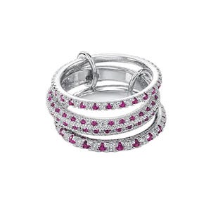 May include: A multi-band ring crafted from polished silver-toned metal, featuring three interconnected circular bands. Each band is encrusted with a continuous row of small, round, vibrant pink gemstones alternating with clear, sparkling white stones.