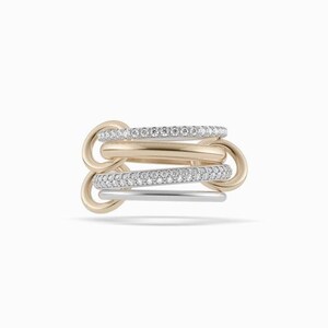 May include: A multi-band ring featuring a combination of polished gold-tone and silver-tone metal bands. Two of the bands are encrusted with small, clear, sparkling stones, while the other bands have a smooth, solid metallic finish.