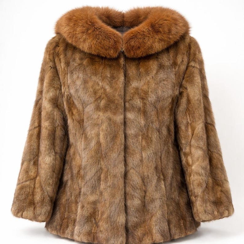May include: A brown fur coat with a contrasting reddish-brown fur collar. The coat has a classic design with a button-up front and long sleeves. The fur appears soft and luxurious, suitable for cold weather.