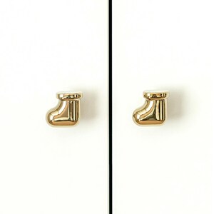 Pu&ograve; includere: Due pomelli dorati per armadi a forma di calza natalizia sono montati su un'anta bianca. I pomelli sono lucidi e riflettono la luce, aggiungendo un tocco di eleganza all'armadio.