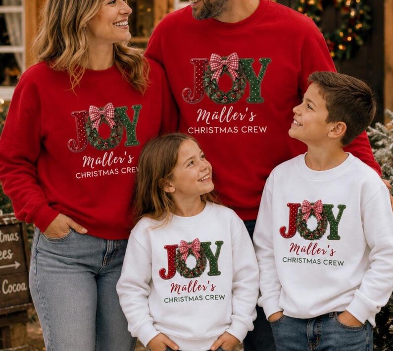 May include: A collection of matching long-sleeve sweatshirts in red and white. Each features the text JOY with a wreath replacing the letter O, topped with a red and white checkered bow. Below, the text reads M&auml;ller's CHRISTMAS CREW.