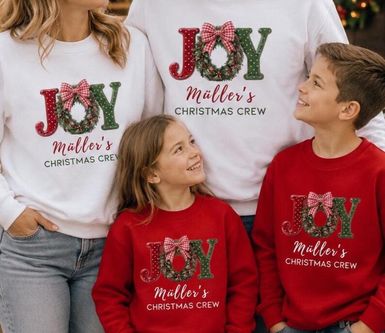 May include: Matching white and red crewneck sweatshirts featuring the word JOY with a green Christmas wreath as the letter O, topped with a red and white gingham bow. The text M&uuml;ller's CHRISTMAS CREW is printed below in a script and sans-serif font.