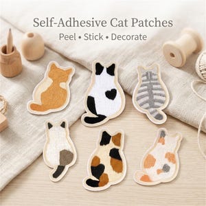 Könnte beinhalten: Sechs gestickte, selbstklebende Katzenaufnäher mit verschiedenen Fellmustern, darunter orange, schwarz-weiß, grau getigert und dreifarbig. Der Text "Self-Adhesive Cat Patches" und "Peel • Stick • Decorate" steht über den Aufnähern.