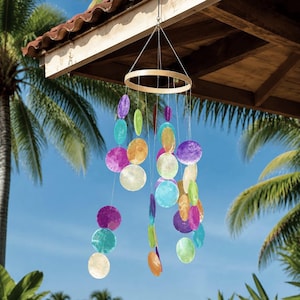 May include: A hanging mobile wind chime featuring a circular wooden frame with multiple translucent, circular discs in shades of purple, blue, green, yellow, and orange suspended by thin strings, creating a colourful, layered, and dangling display.