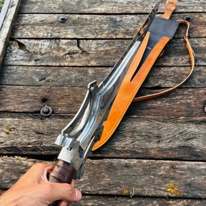 Side angle view of the handmade fantasy knife with leather sheath showing thickness, structure, and overall build quality. The blade appears balanced and well crafted, while the sheath adds protection and style. Ideal for collectors and gifting occasions.