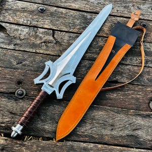 Knife with belt style leather sheath strap shown in detail, highlighting portability and secure carrying option. The strap is made from quality leather and complements the overall design. Ideal for collectors and as a gift item.