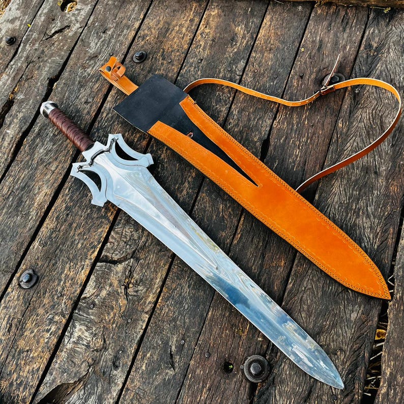 Long blade handmade fantasy knife shown in full product display with sheath placed alongside, emphasizing its impressive length and balanced proportions. The blade features a smooth polished finish while the guard has a bold, artistic shape. Ideal for collectors looking for a unique display piece or as a meaningful gift option for husband or loved ones.