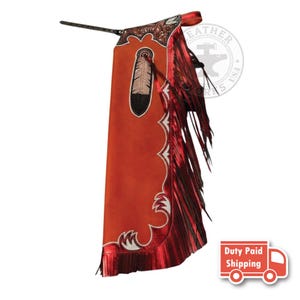 Puede incluir: Una chaparrera de cuero color óxido con un diseño de incrustación de pluma marrón oscuro, costuras decorativas blancas a lo largo de los bordes festoneados y flecos largos de color rojo metálico. Incluye una correa negra ajustable.