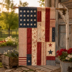 May include: A rectangular fabric garden flag featuring a patchwork design with a dark blue canton containing embroidered white stars. The flag incorporates vertical strips of red, cream, and blue fabric with floral, striped, and gingham patterns.