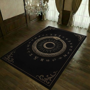Op de afbeelding: Een rechthoekig zwart vloerkleed met een centraal goudkleurig Ouroboros-ontwerp, dat een slang uitbeeldt die in zijn eigen staart bijt. Het kleed is versierd met een cirkelvormige rand van geometrische symbolen en gouden hoekversieringen.