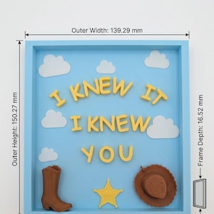 Pu&ograve; includere: Una cornice azzurra a cassetta con il testo giallo "I KNEW IT I KNEW YOU", nuvole bianche, uno stivale da cowboy marrone, una stella da sceriffo gialla e un cappello da cowboy marrone. Larghezza 139,29 mm, altezza 150,27 mm, profondit&agrave; 16,52 mm.