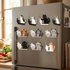 May include: A collection of cat-themed refrigerator magnets. Each magnet features a cat holding a vase with decorative stems. The cats are in various colors and patterns, including black, white, orange, and gray. The magnets are attached to a stainless steel refrigerator.