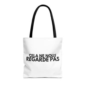 Peut inclure: Sac fourre-tout blanc avec des anses noires. Le sac affiche la phrase française "CELA NE NOUS REGARDE PAS" en lettres noires et grasses. Un accessoire pratique et élégant.