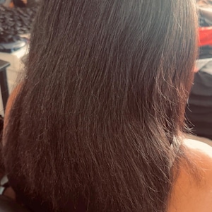 Pode incluir: Cabelo longo, liso e castanho escuro que ultrapassa os ombros. O cabelo tem uma textura natural com fios individuais vis&iacute;veis e um brilho subtil, parecendo espesso e saud&aacute;vel &agrave; medida que cai pelas costas.