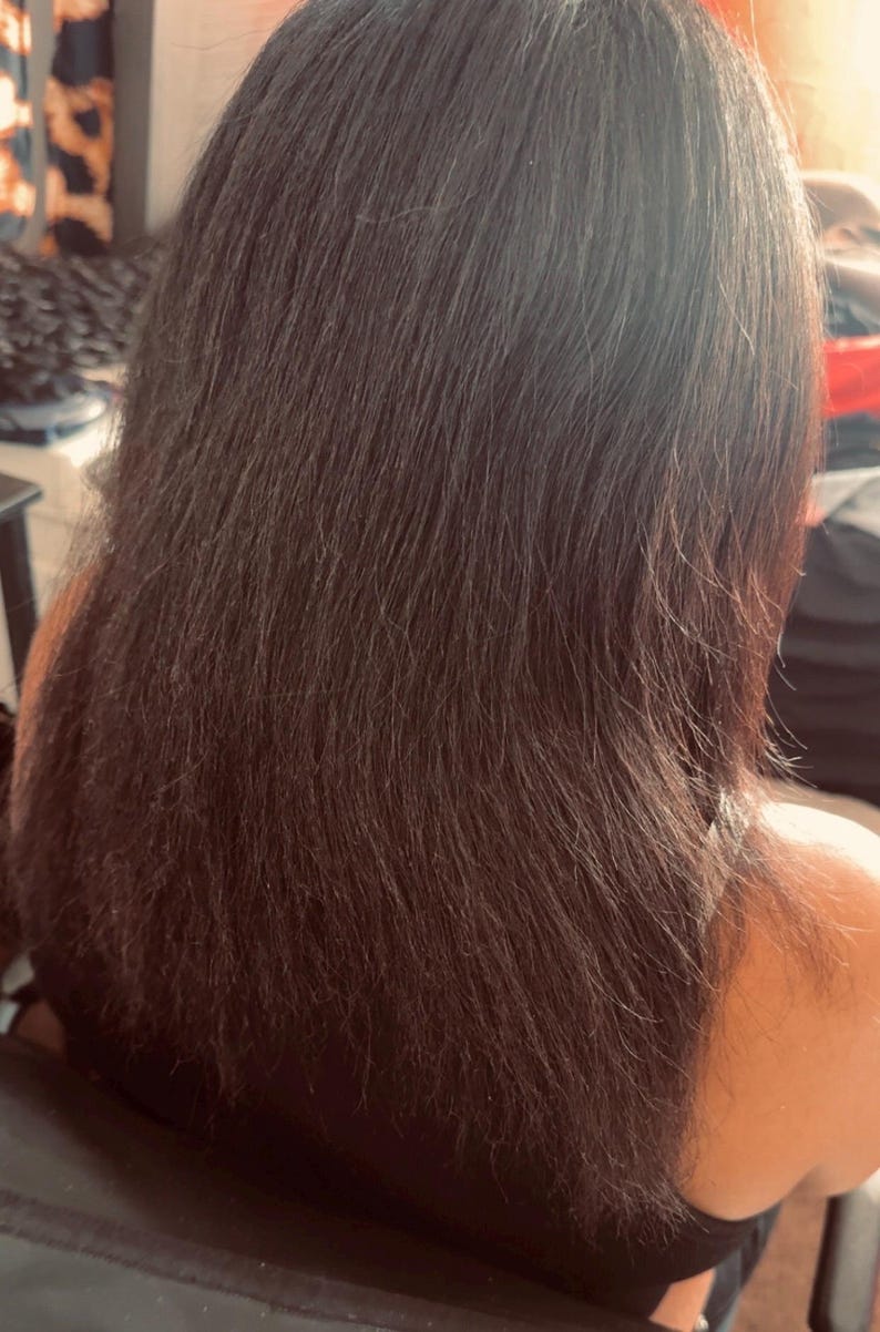 Pode incluir: Cabelo longo, liso e castanho escuro que ultrapassa os ombros. O cabelo tem uma textura natural com fios individuais vis&iacute;veis e um brilho subtil, parecendo espesso e saud&aacute;vel &agrave; medida que cai pelas costas.