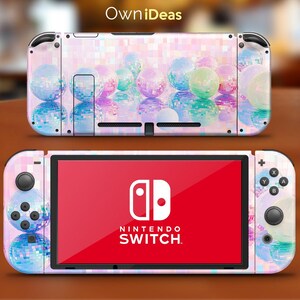 Könnte beinhalten: Eine Nintendo Switch-Konsole mit einem individuellen Skin mit einem farbenfrohen Discokugel-Design. Der Skin bedeckt die Konsole und die Joy-Con-Controller, wobei das Nintendo Switch-Logo auf dem Bildschirm sichtbar ist. Das Design umfasst Pastellfarben und den Text "OwniDeas".