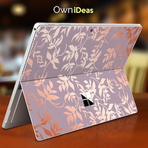 May include: A tablet with a lavender and rose gold floral design. The tablet is open, displaying the decorative pattern on the back and cover. The text "OwniIdeas" is visible in the top left corner.