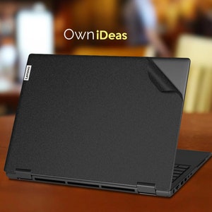 May include: A black laptop computer with the Lenovo logo on the lid. The laptop is closed and has a black screen protector on the lid. The laptop is sitting on a wooden table. The text "OwnIdeas" is written in yellow letters above the laptop.