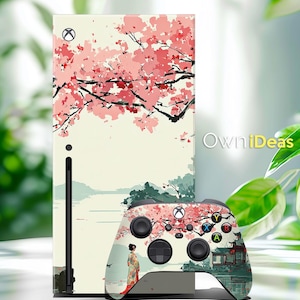 Może przedstawiać: Skórka na konsolę Xbox Series X i kontroler w stylu japońskim. Skórka konsoli przedstawia kwitnącą wiśnię z różowymi kwiatami i czarnymi gałęziami. Kontroler ma pasujący design z gejszą i tradycyjnym budynkiem.