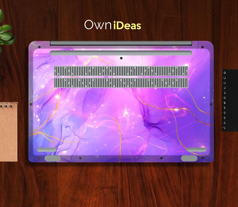 May include: Purple laptop skin with a marble pattern and gold accents. The skin has a subtle shimmer and a galaxy-like design. The text "OwnIdeas" is printed on the top of the skin.
