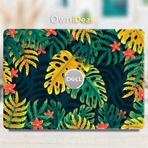 Puede incluir: Una piel para portátil con un diseño de hojas tropicales en verde, amarillo y rojo. La piel tiene un logotipo de Dell en el centro.