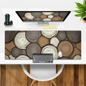 May include: A brown and beige desk mat with a pattern of concentric circles resembling tree rings. The mat is on a white desk with a keyboard and a mouse.