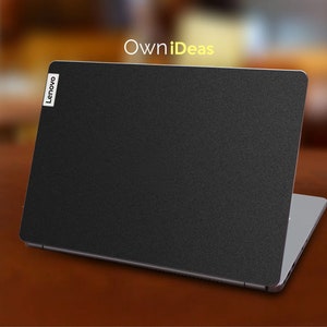May include: A black laptop with a textured surface and the word "Lenovo" in white on the lid. The laptop is closed and sitting on a wooden surface. The text "OwnIdeas" is visible in the background.