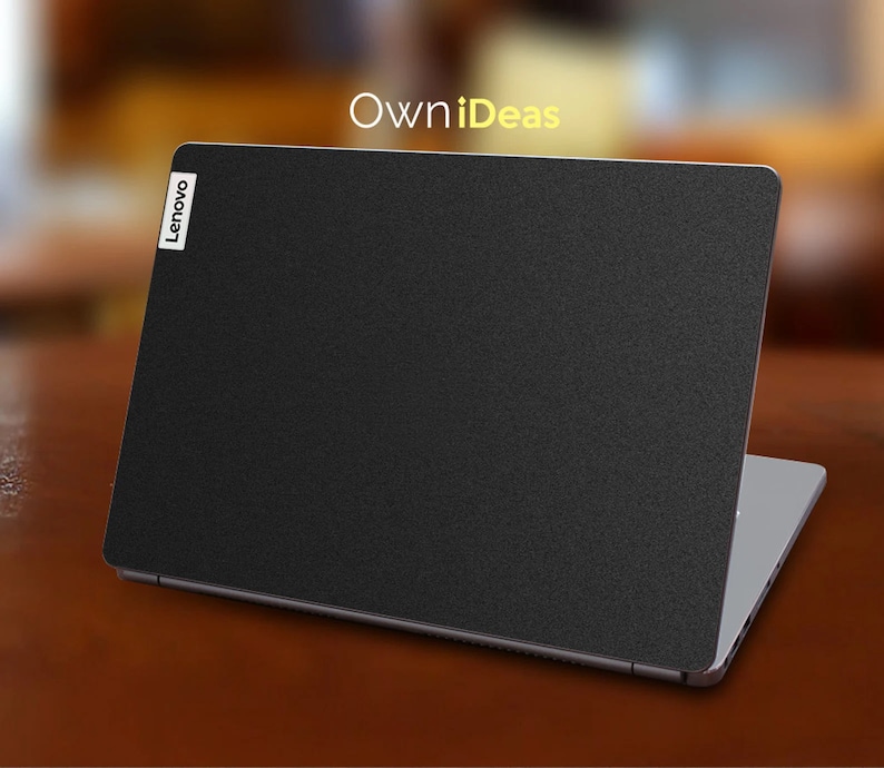May include: A black laptop with a textured surface and the word "Lenovo" in white on the lid. The laptop is closed and sitting on a wooden surface. The text "OwnIdeas" is visible in the background.