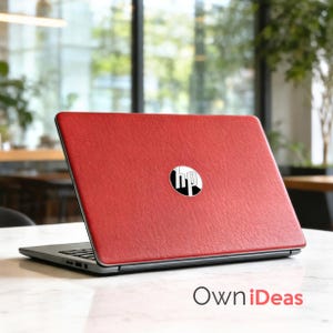 K&ouml;nnte beinhalten: Roter Laptop mit dem HP-Logo auf dem Deckel. Der Laptop ist auf einer wei&szlig;en Oberfl&auml;che ge&ouml;ffnet. Der rote Deckel des Laptops hat ein strukturiertes Aussehen. Der Text "OwniIdeas" ist unten im Bild sichtbar.
