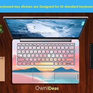 Op de afbeelding: Laptop toetsenbord stickers met een landschapsontwerp in roze, blauwe en gele tinten. De toetsenbordtoetsen zijn wit met zwarte letters. De tekst bovenaan luidt "Keyboard key stickers are Designed for US standard keyboards."