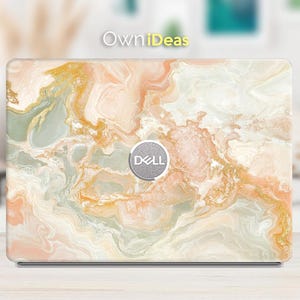 May include: A laptop skin with a marble design featuring swirls of white, peach, and green with gold accents. The skin has a Dell logo in the centre.
