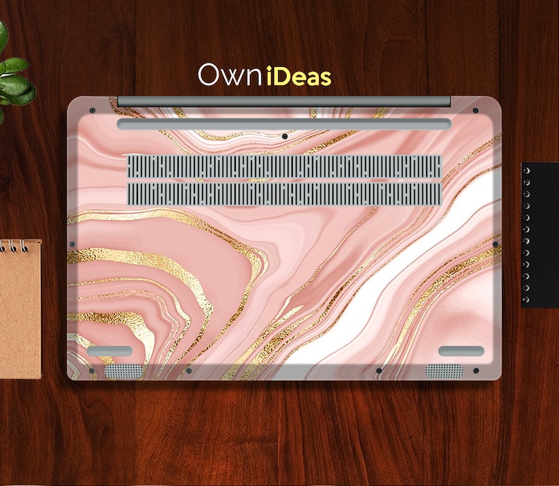 Puede incluir: Una piel de port&aacute;til de m&aacute;rmol rosa y dorado con el texto "OwnIdeas" impreso en la parte superior.