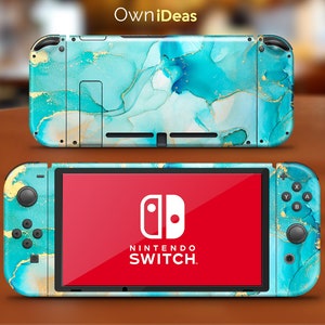 Puede incluir: Una piel para consola Nintendo Switch turquesa y dorada con un diseño de mármol abstracto. La piel se aplica en la parte delantera y trasera de la consola, así como en los mandos Joy-Con.