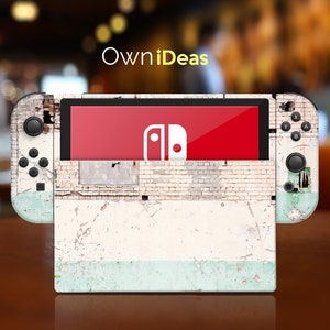 Könnte beinhalten: Eine weiße und blaue Nintendo Switch Konsolenhaut mit einem abgenutzten Backsteinmauer-Design. Die Haut hat einen verblassten, abgenutzten Look mit einem hellblauen Akzent am unteren Rand.