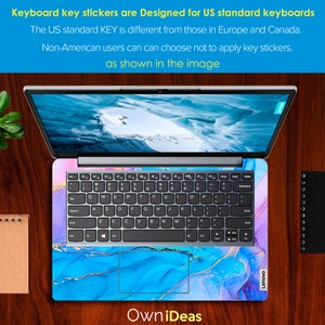 K&ouml;nnte beinhalten: Ein Laptop mit einem blauen, rosa und goldenen Marmorsticker f&uuml;r die Tastatur. Der Sticker hat ein Design, das an Aquarell erinnert. Der Laptop ist ge&ouml;ffnet und auf dem Bildschirm ist eine schneebedeckte Berglandschaft zu sehen. Der Text "OwniDeas" ist unter dem Laptop sichtbar.