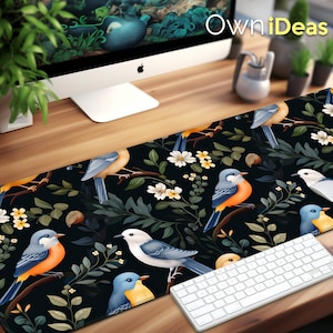 May include: A black and blue mouse mat with a floral design and colourful birds. The mouse mat features a white keyboard with black keys. The text "OwnIdeas" is visible in the top right corner of the image.