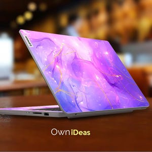 May include: A purple and blue laptop with a gold marble design. The laptop has the Lenovo logo on the back.
