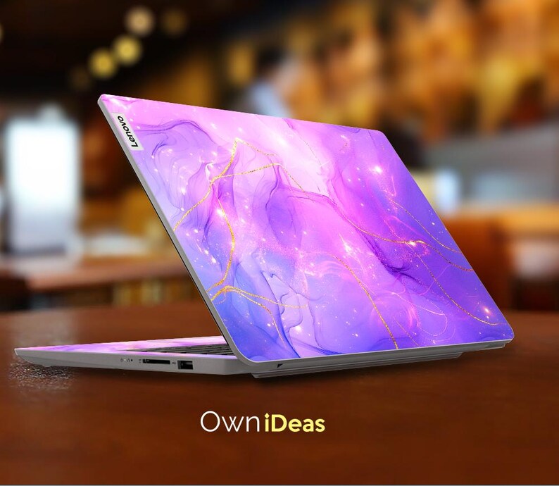 May include: A purple and blue laptop with a gold marble design. The laptop has the Lenovo logo on the back.