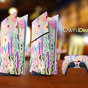 May include: A floral patterned skin for a Playstation 5 console and controller. The design features pink, purple, green, and white flowers on a light blue background. The text "OwnIdeas" is visible in the image.