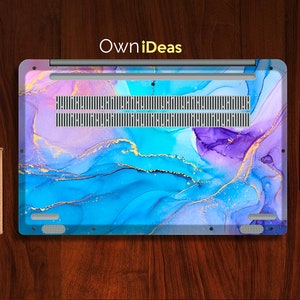 K&ouml;nnte beinhalten: Eine Laptop-Haut mit einem abstrakten Design in Blau, Lila und Gold. Das Design zeigt wirbelnde Muster und goldene Glitzer-Akzente. Die Haut ist aus strapazierf&auml;higem Material gefertigt und soll Ihren Laptop vor Kratzern und Abnutzung sch&uuml;tzen.